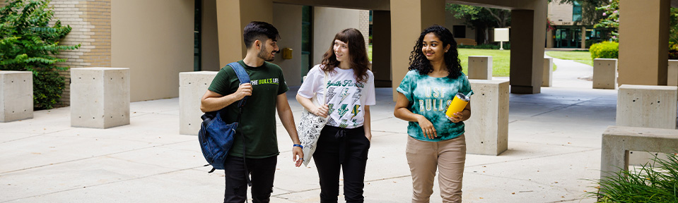 Three ֱ students walking by Castor Hall on campus.