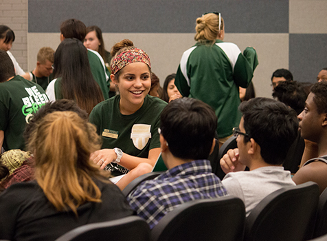 A student leader is talking to a group of fellow students