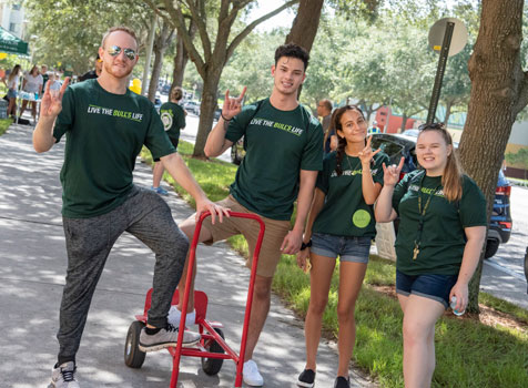 Students on campus do the "Go Bulls" hand symbol