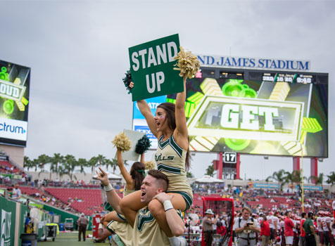 Cheerleaders encouraging fans to stand up