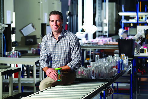 Rogan Donelly sitting in a Tervis factory while holding a Tervis tumbler