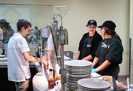 Two hospitality students work behind the counter of an on-campus restaurant