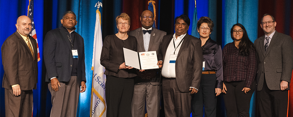 Group stands on stage to receive NSF award