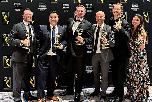 Group stands holding Emmy statues