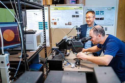 Jing Wang, professor of electrical engineering, and Ugur Guneroglu, graduate student, working on micromachined on-chip microwave acoustic resonators and filters for integrated RF and microwave front end systems.
